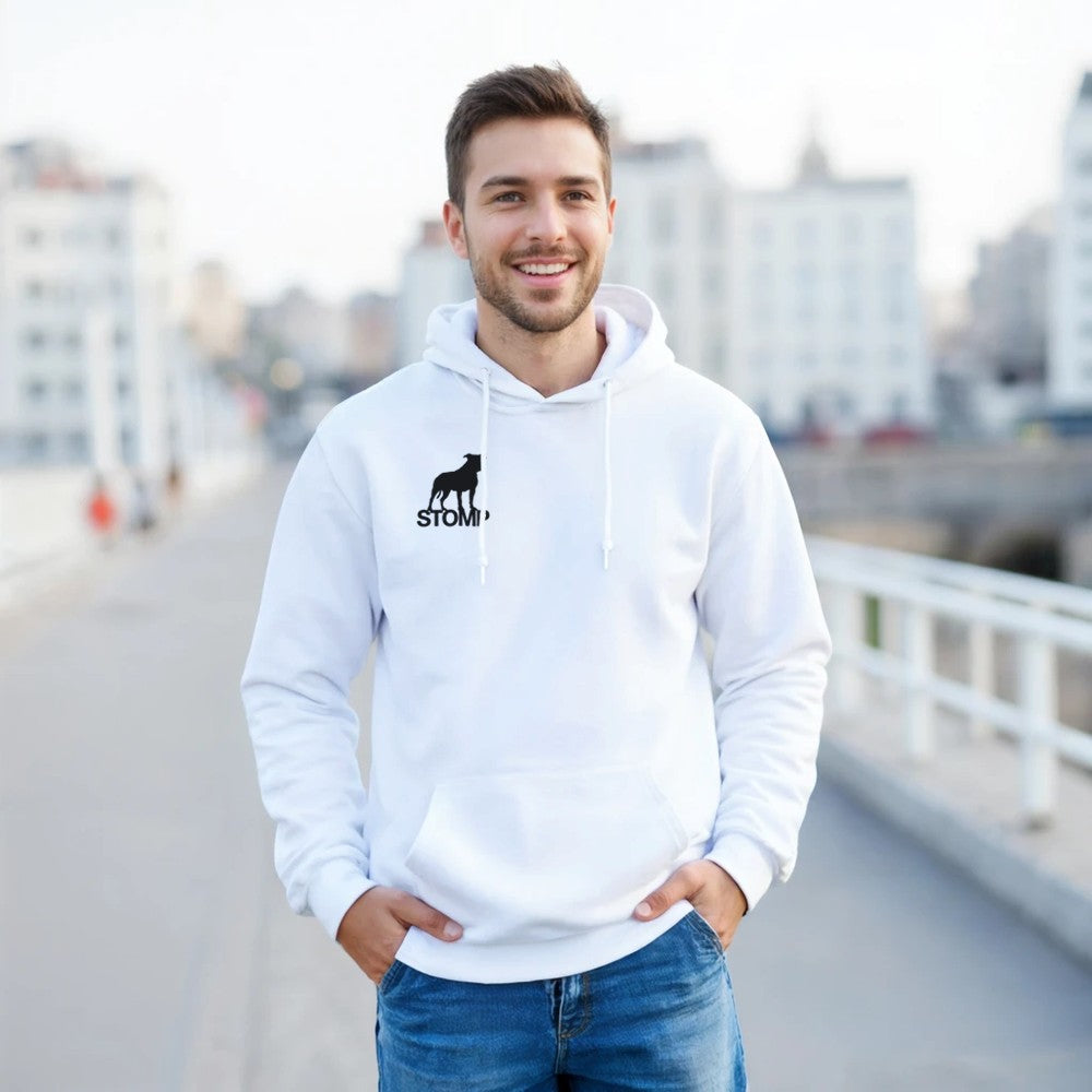 Man wearing a white hoodie with a logo, standing on a bridge with a cityscape background