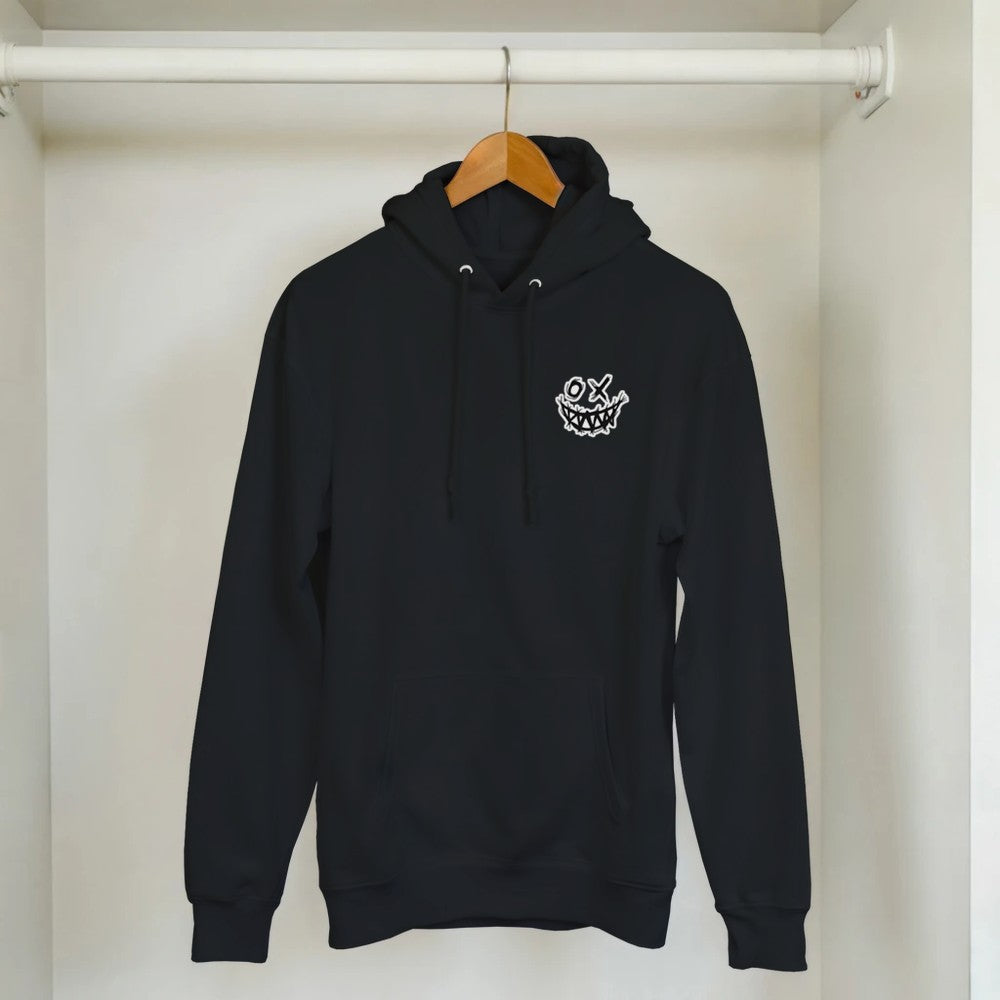 Black hoodie with a small white graphic on a wooden hanger against a white wall. Drum and bass